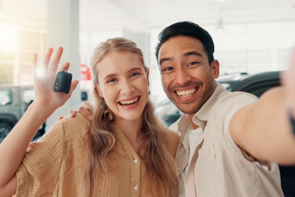 young couple holding the keys to their brand new car