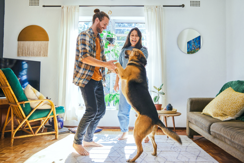 couple dancing with their dog in the living room