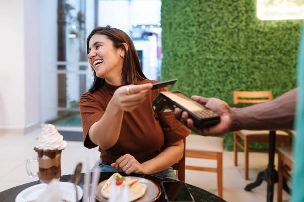 woman laughing and paying with her credit card